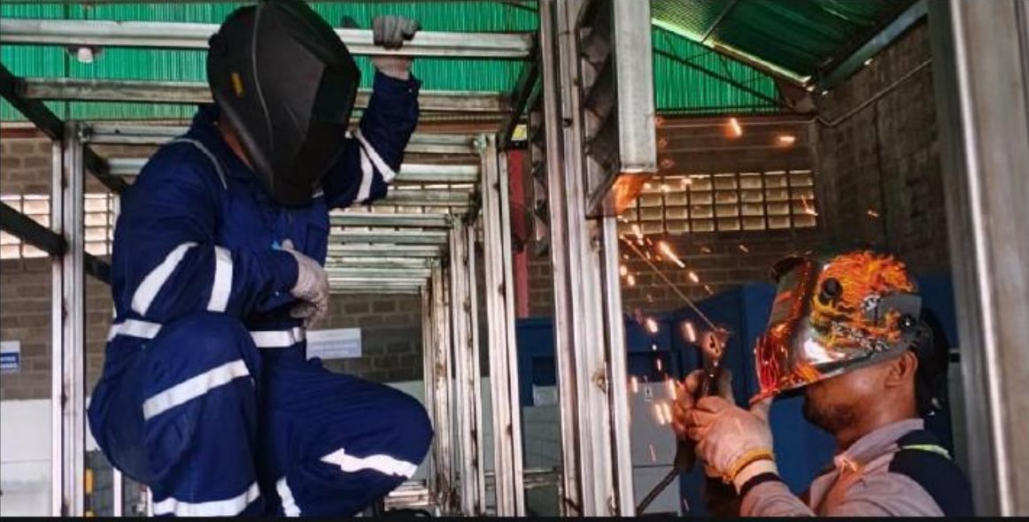 Personnel carrying out welding and fabrication in a workshop